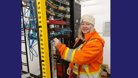 Natalie wearing a safety jacket while at work in a data centre.