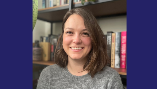 Bailey smiling with a bookshelf in the background.